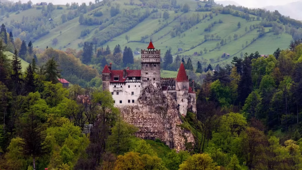 The majestic Bran Castle sits in the middle, surrounded by lush forest. 
